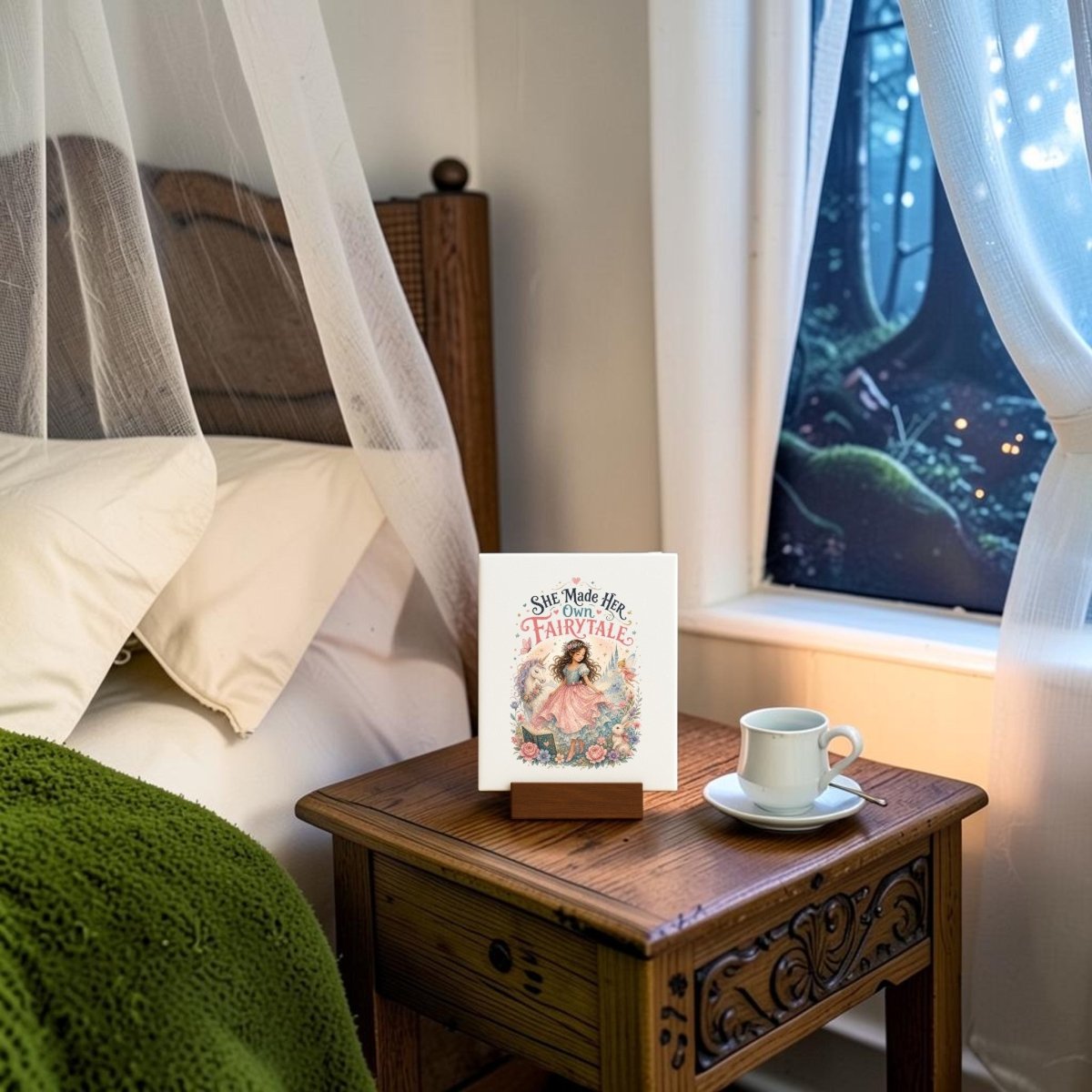 A cozy bedroom scene featuring a bed with a green blanket, a nightstand displaying Mirabilia Boutique’s "She Made Her Own Fairytale" mini canvas, alongside a white cup and saucer and the book titled "She Made Her Life a Fairytale." A window frames views of a tree with twinkling lights outside—perfect inspiration for children's room decor or accenting any space with whimsical touches like this fairytale-themed mini canvas art.