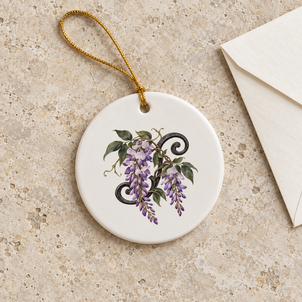 Wisteria at Blue Hour Ornament by Mirabilia Boutique, a round white ceramic ornament with an illustration of purple flowers and black decorative scrolls, hanging by a gold cord.