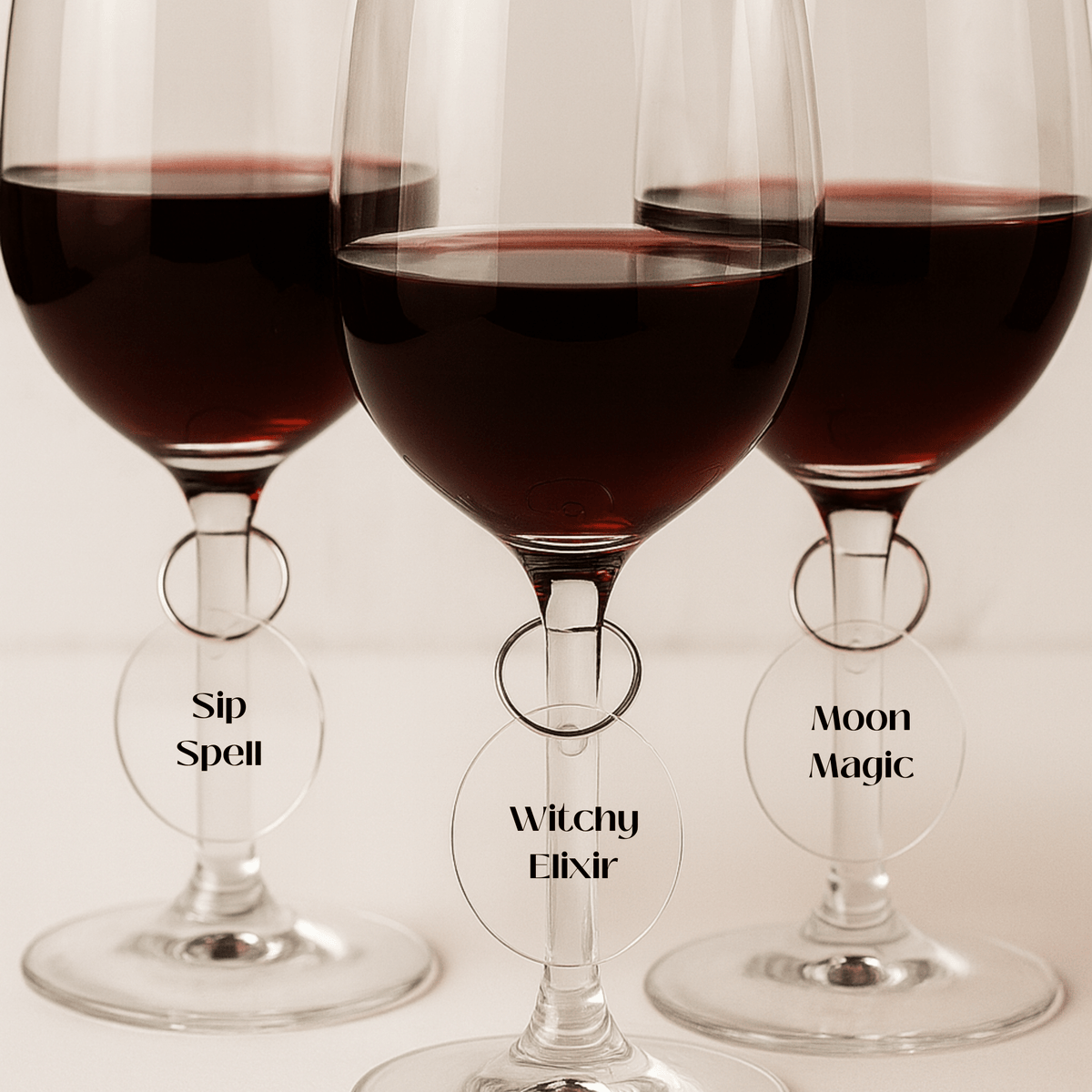 Add a magical touch to your table with the Witchy Wine Charms Set | Halloween Glass Tags by Mirabilia Boutique—each glass tag reads "Sip Spell," "Witchy Elixir," or "Moon Magic" for enchanting Halloween vibes.
