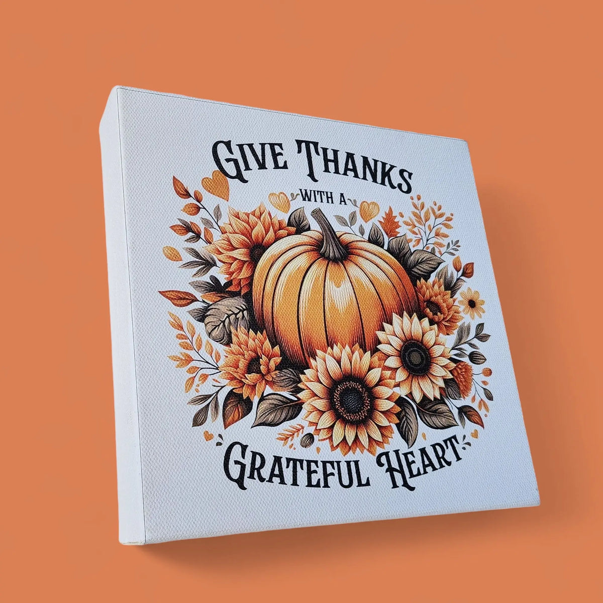 The Mirabilia Boutique "Give Thanks With a Grateful Heart" wood sign is an 8x8 fall wall art featuring a pumpkin and sunflowers—perfect Thanksgiving décor to add a warm, rustic touch to your home.