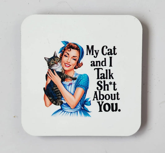 The Snarky Retro Housewife Magnet: Cat Conversations About You by Mirabilia Boutique showcases a smiling woman in a blue dress holding her cat, with the witty text "My Cat and I Talk Sh*t About You." This magnet is perfect for cat lovers and humor enthusiasts, featuring an illustration that stands out beautifully against a white background.