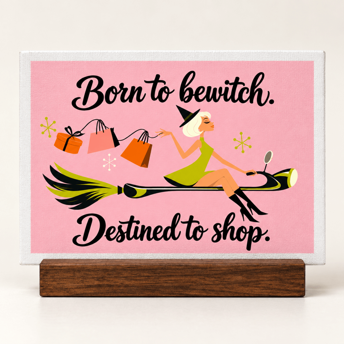 A Little Retail Magic Mini Sign | Fall Vibes featuring a retro cartoon witch on a wooden stand riding a broomstick with shopping bags and the text “Born to bewitch. Destined to shop.”