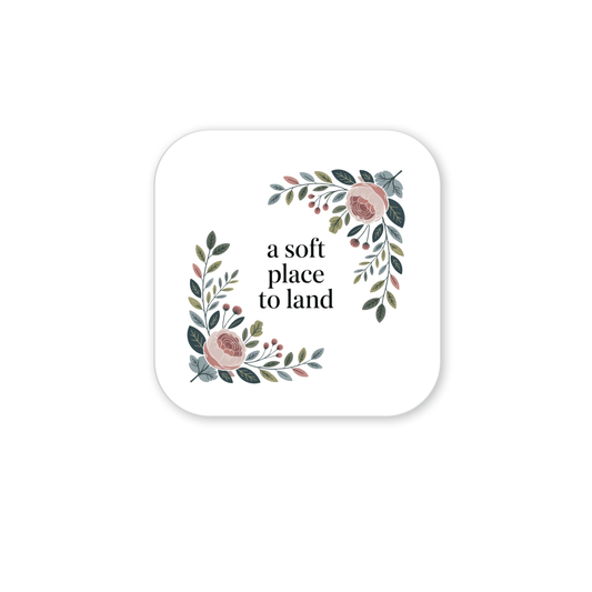 The A Soft Place to Land Floral Magnet by Mirabilia Boutique features a white square with rounded corners, floral pink and green accents, and the phrase “a soft place to land”—perfect for fans of botanical décor and cottagecore style.