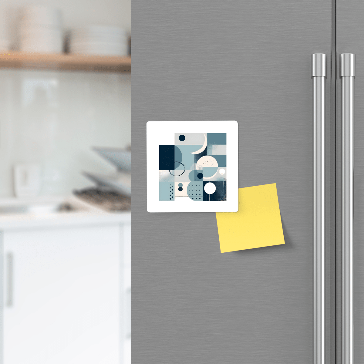 A Mirabilia Boutique Moonlit Geometry Mid Century Modern Magnet and a blank yellow sticky note are displayed on a refrigerator door, with a blurred kitchen in the background.
