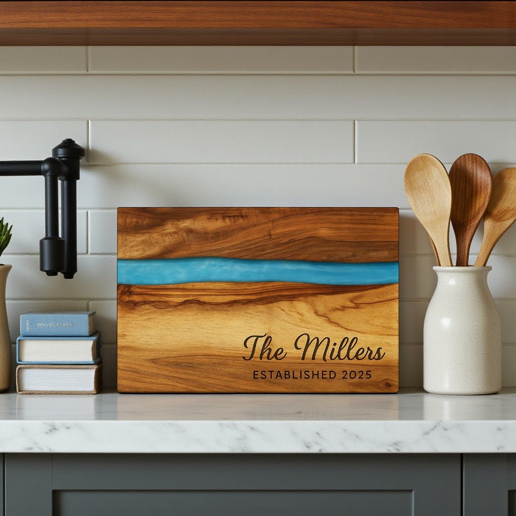 The Mirabilia Boutique Engraved Resin Acacia Board – Housewarming or Wedding, personalized with "The Millers Established 2025," sits on a kitchen counter—an ideal custom gift for weddings or housewarmings.