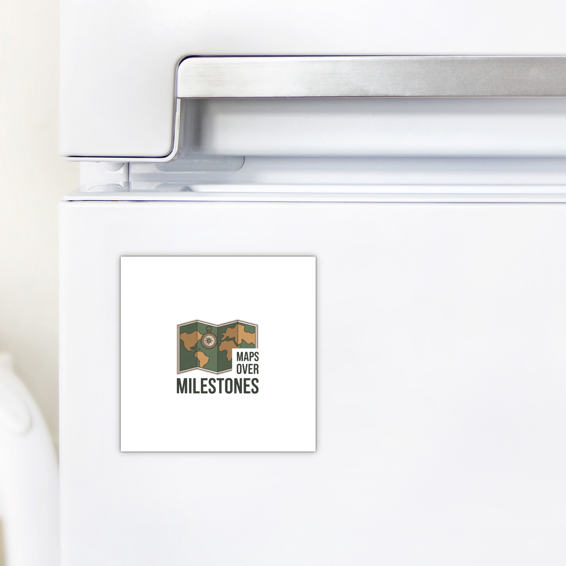 The Maps Over Milestones Travel Magnet by Mirabilia Boutique features a map illustration and bold "MAPS OVER MILESTONES" text—a square, adventure-inspired décor piece perfect for refrigerators or as a gift for explorers.