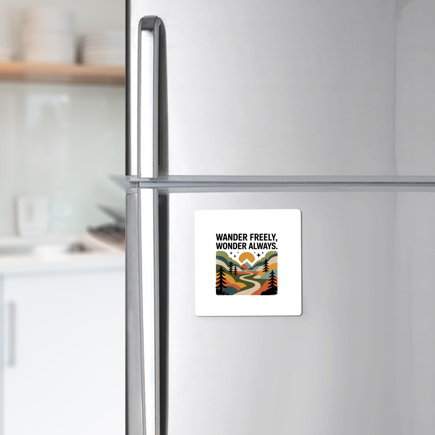 The Wander Freely Wonder Always Adventure Magnet by Mirabilia Boutique features a scenic path among trees and mountains with "Wander Freely. Wonder Always." printed above, perfect for displaying on your silver refrigerator.
