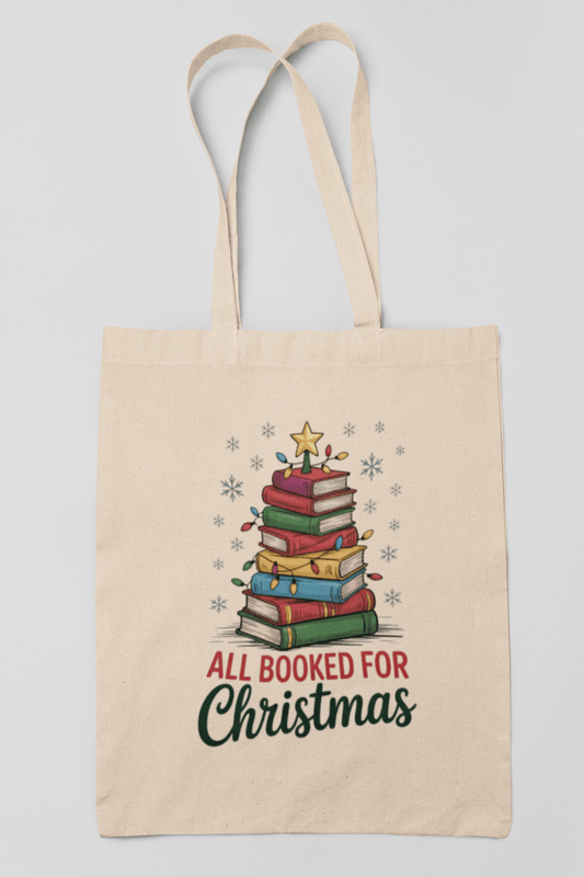The All Booked for Christmas Book Stack Tote Bag by Mirabilia Boutique features a festive stack of colorful books as a Christmas tree with lights, star, and snowflakes. “All Booked For Christmas” text makes it the perfect gift for any book lover.