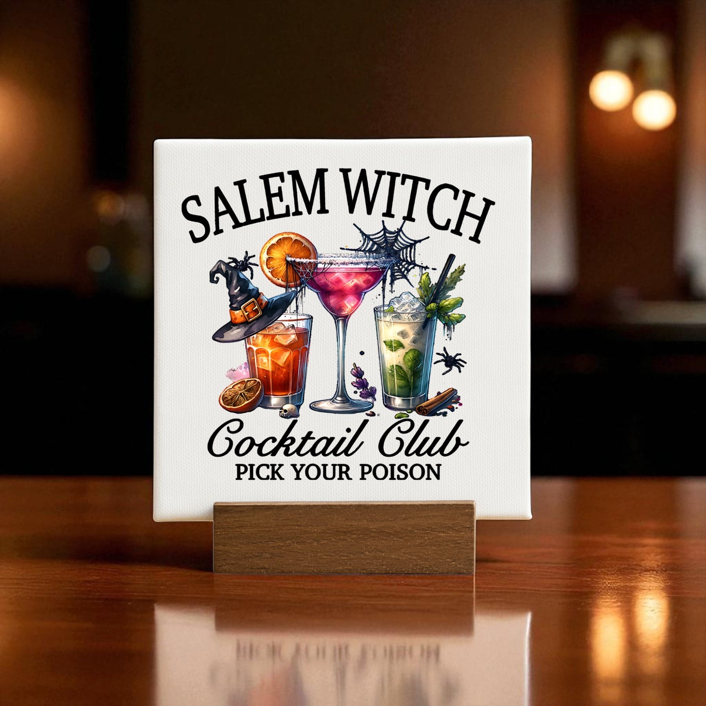 The Mirabilia Boutique Salem Soirée Halloween Cocktail Kit features a sign reading "Salem Witch Cocktail Club Pick Your Poison," wine charms, cocktail recipes, and festive decorations—a perfect spooky touch for your party!.