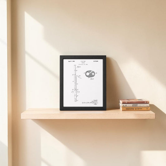 The Mirabilia Boutique Bassoon Patent Print on Metal Wall Art is displayed on a light wooden floating shelf beside three stacked books, with soft sunlight highlighting the piece against a cream-colored wall.
