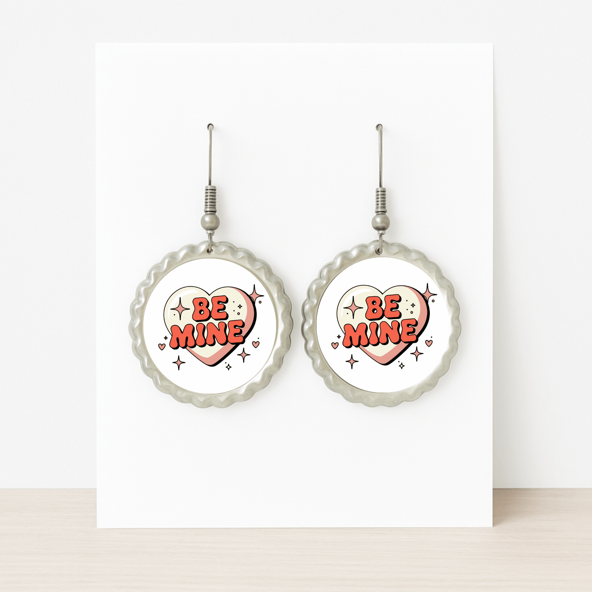 Mirabilia Boutique’s Be Mine Heart Earrings feature a retro scalloped design with bold red “BE MINE” hearts—displayed on a white card, they make a cute Valentine jewelry gift.