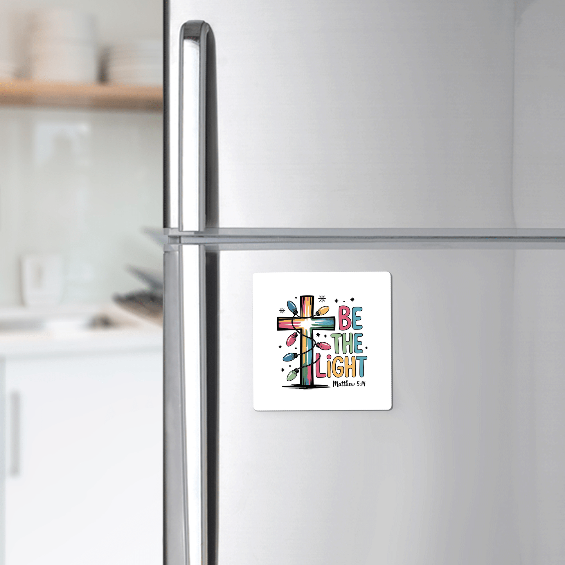 The Be the Light Magnet by Mirabilia Boutique features a vibrant cross and Matthew 5:14—an uplifting Christian fridge decor, ideal as a faith-inspired gift or stocking stuffer for any modern kitchen.