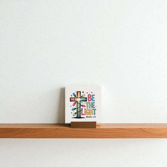 The Be the Light Mini Sign | Christian Christmas Decor 4x4 by Mirabilia Boutique adds a colorful, inspirational touch to any shelf—ideal as a Christian gift or festive accent for a plain white wall.