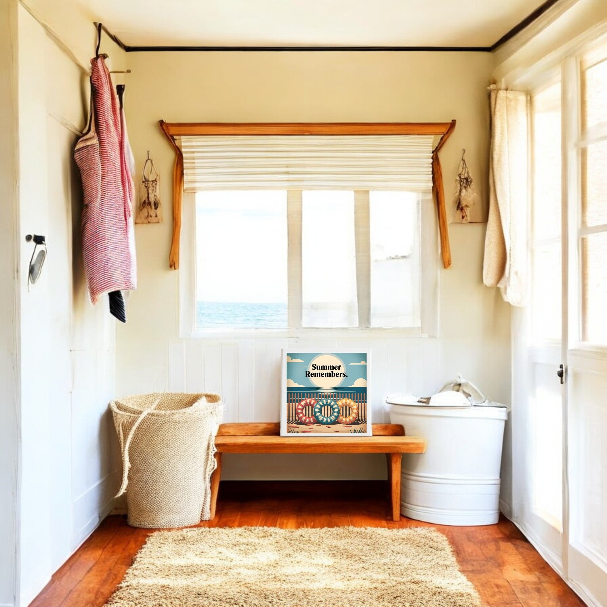 A bright room with wooden floors features a woven laundry basket, white bin, and wooden bench. The "Summer Remembers Canvas Wall Art – Coastal Nostalgia" by Mirabilia Boutique adds beach cottage charm beneath a sunlit window.