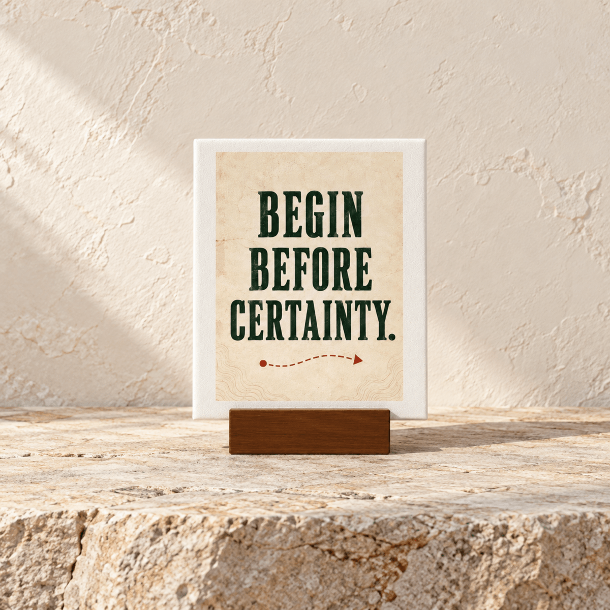 Begin Before Certainty Mini Sign on a wooden stand, featuring a red dashed line and arrow below the text on a small rectangular board.