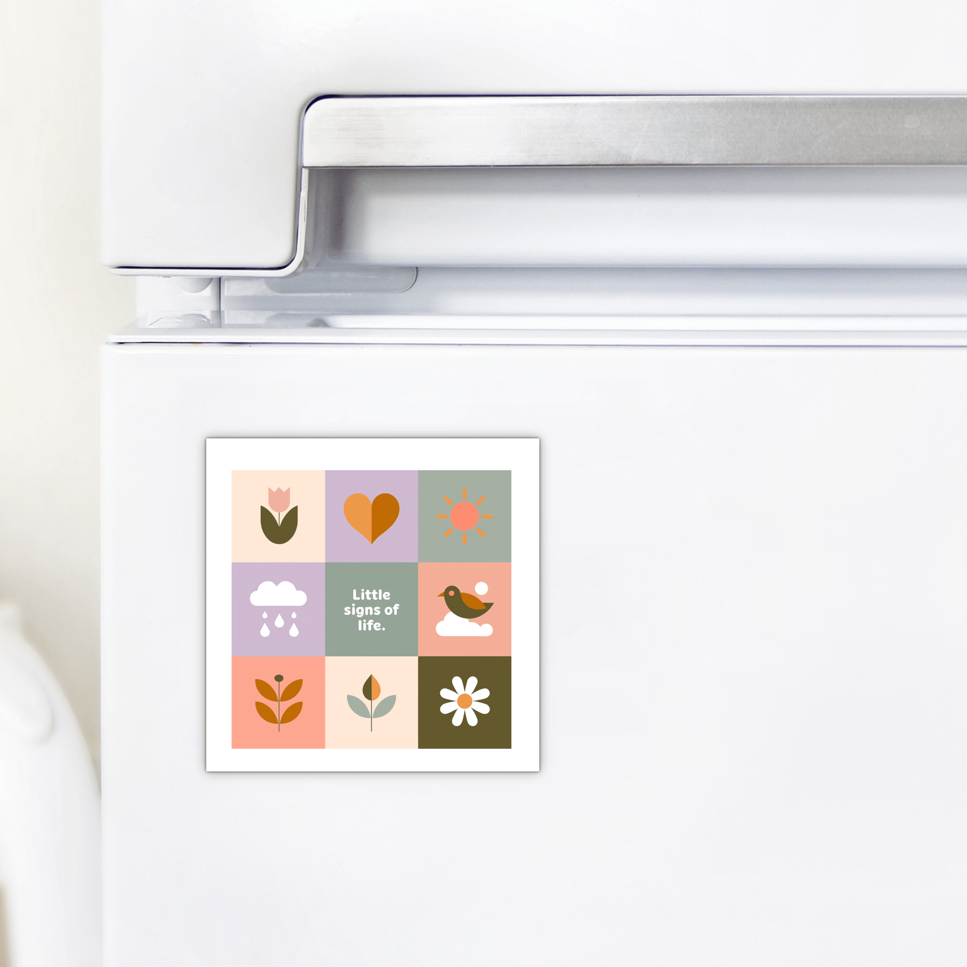 The Little Signs of Life Pastel Grid Magnet by Mirabilia Boutique features simple pastel drawings—flower, sun, heart, and more—with the phrase "Little signs of life." An inspiring minimalist decor piece for your fridge or a thoughtful gift.
