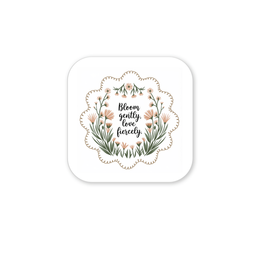The Bloom Gently Love Fiercely Floral Magnet by Mirabilia Boutique is a square magnet with scalloped edges, decorated with orange and green wildflowers and the quote "Bloom gently, love fiercely" in elegant script.