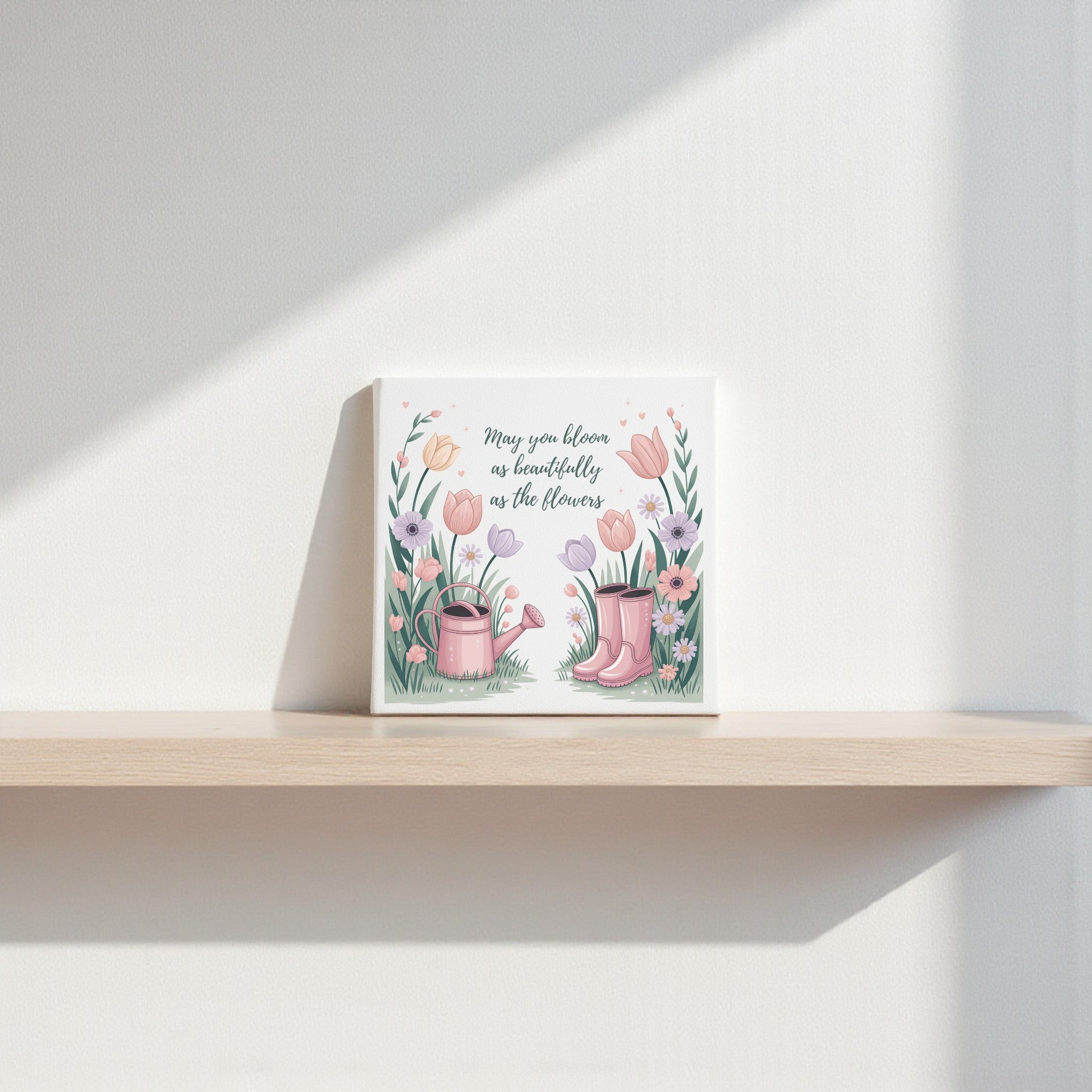 The Bloom Like the Flowers Canvas Art by Mirabilia Boutique features pink rain boots, a watering can, and flowers with the quote "May you bloom as beautifully as the flowers"—perfect spring wall decor for a light-filled home.