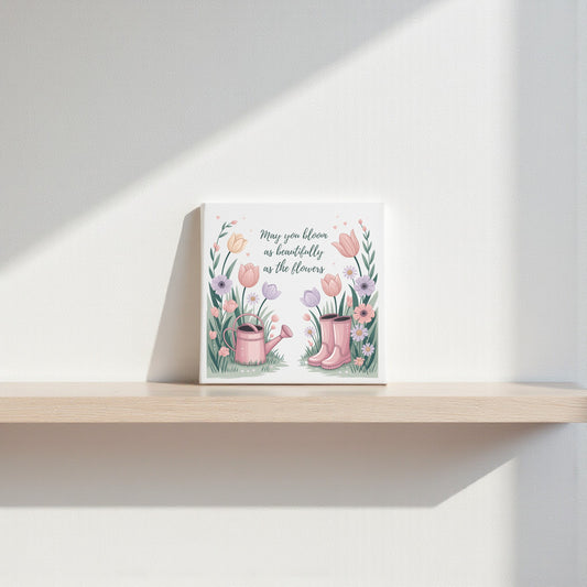 The Bloom Like the Flowers Canvas Art by Mirabilia Boutique features pink rain boots, a watering can, and flowers with the quote "May you bloom as beautifully as the flowers"—perfect spring wall decor for a light-filled home.