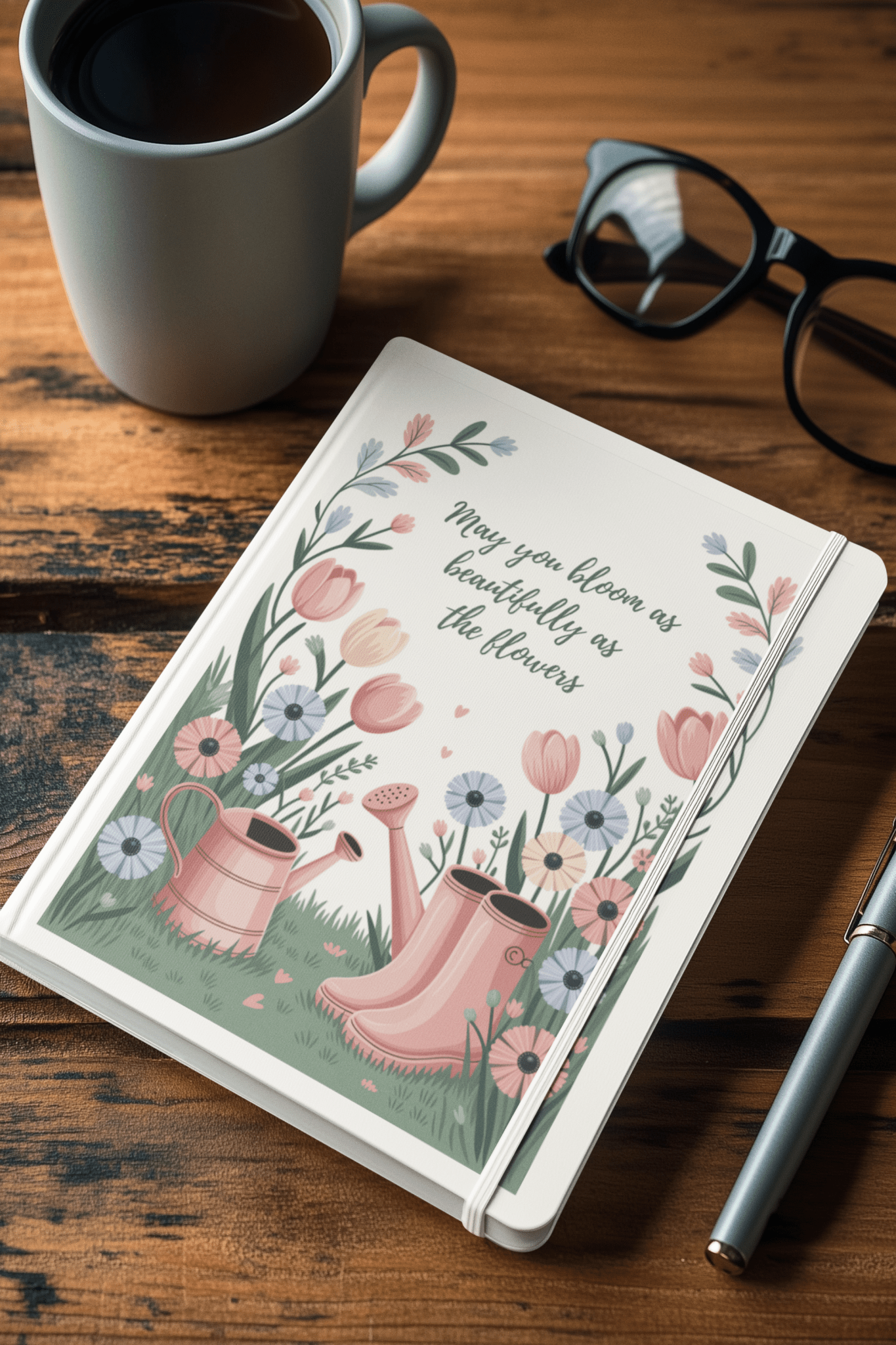 The Bloom Like the Flowers Journal – A5 Spring Floral Notebook by Mirabilia Boutique features floral art, a watering can, boots, and the phrase "May you bloom as beautifully as the flowers"—a perfect gift for garden lovers.