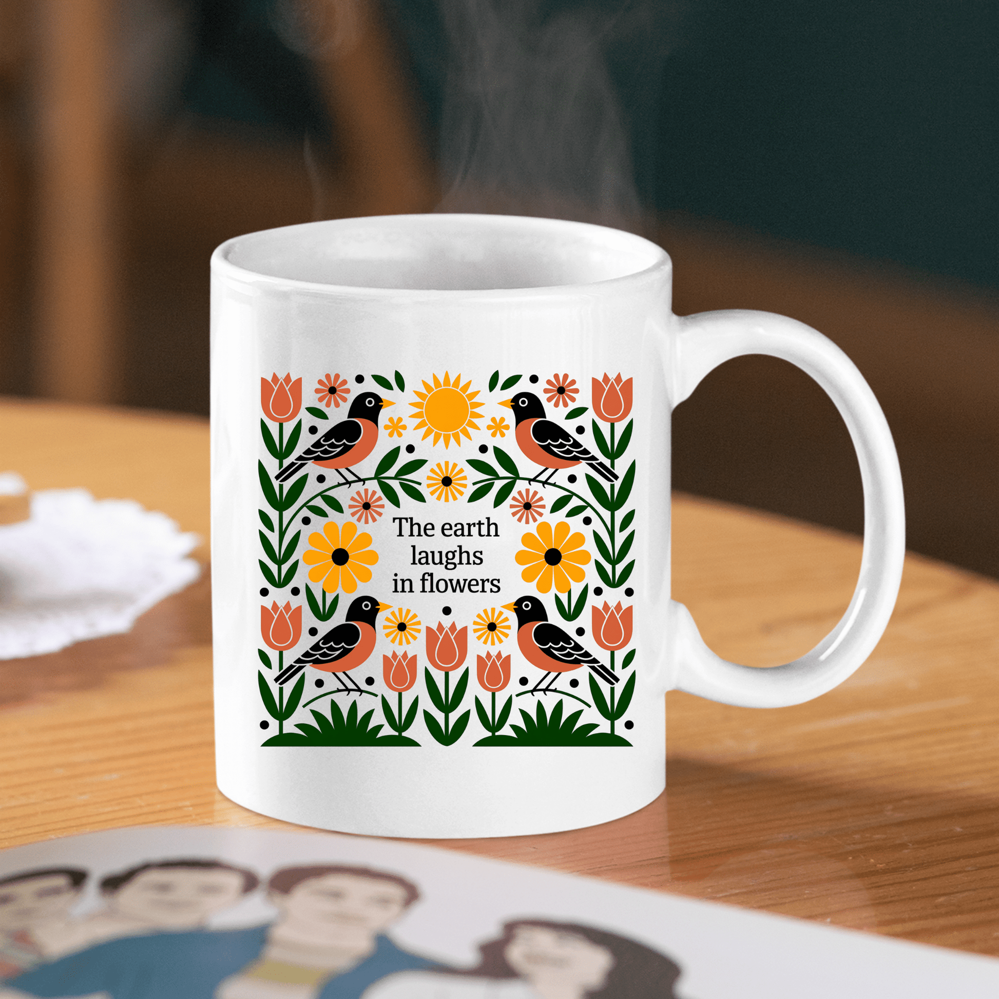 The Earth Laughs in Flowers Spring Mug by Mirabilia Boutique features colorful flowers, leaves, and birds with the quote "The earth laughs in flowers." Ideal for nature lovers, it brings spring vibes to your table.