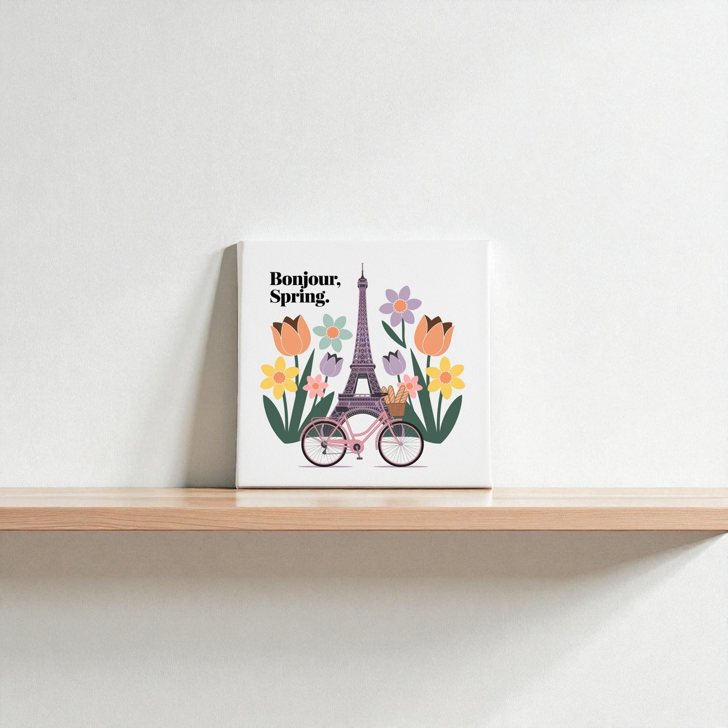 The Bonjour, Spring Canvas – Eiffel Tower Floral Art by Mirabilia Boutique features a spring Paris scene with the Eiffel Tower, colorful tulips, and a pink bicycle beside "Bonjour, Spring" text on white.