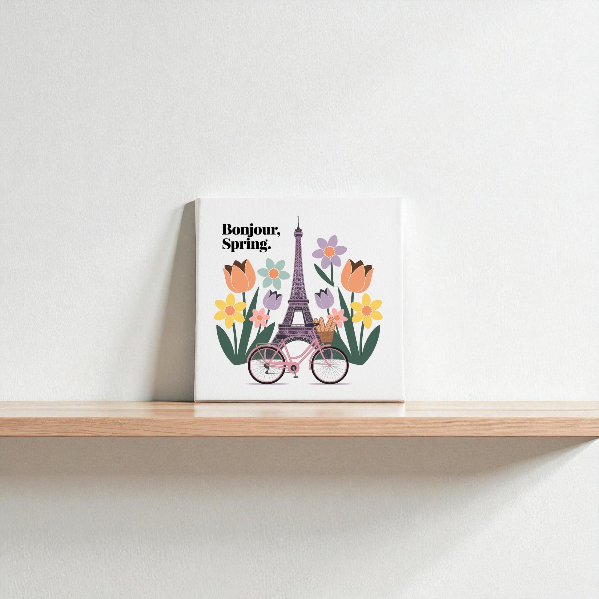 The Bonjour, Spring Canvas – Eiffel Tower Floral Art by Mirabilia Boutique features a spring Paris scene with the Eiffel Tower, colorful tulips, and a pink bicycle beside "Bonjour, Spring" text on white.