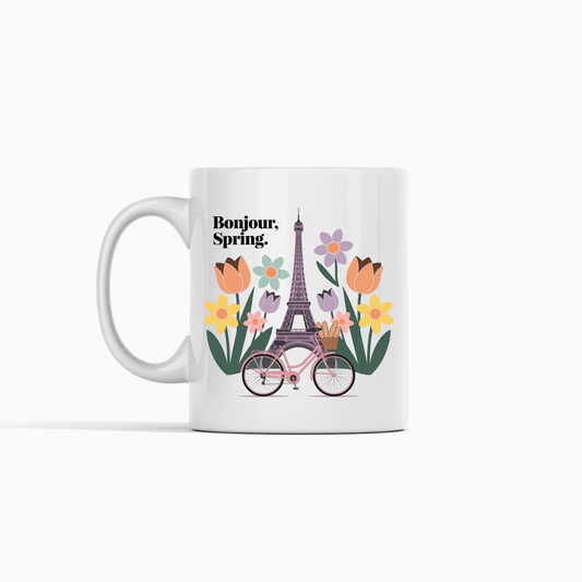 Enjoy your favorite drink in the "Bonjour Spring Paris Mug – Eiffel Tower & Florals" by Mirabilia Boutique, featuring Parisian charm with the Eiffel Tower, florals, a bicycle with baguettes, and "Bonjour, Spring.