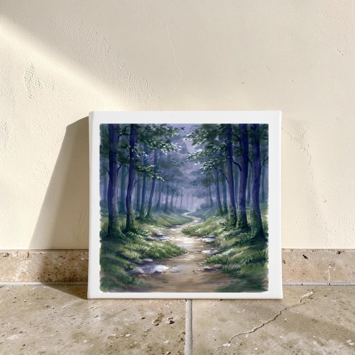 Borrow a Little Moonlight Forest Canvas Wall Art by Mirabilia Boutique features a serene scene of a forest path with tall green trees and sunlight streaming through, elegantly propped against a beige wall on a tiled floor—an ideal piece for tranquil woodland-inspired decor.