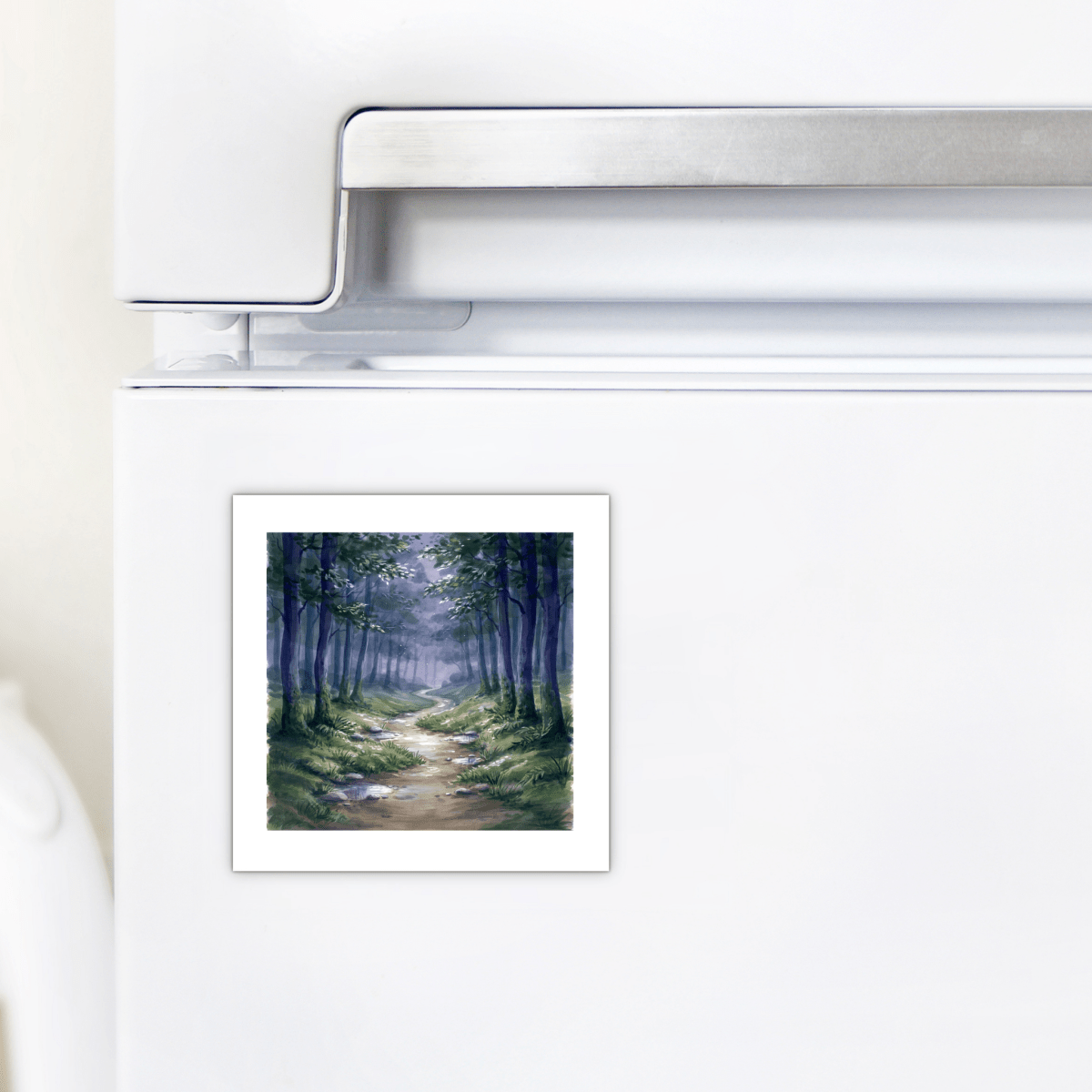 The Borrow a Little Moonlight Forest Magnet by Mirabilia Boutique, featuring a miniature artwork of a forest path with trees and a winding dirt trail, is displayed on a white refrigerator door.