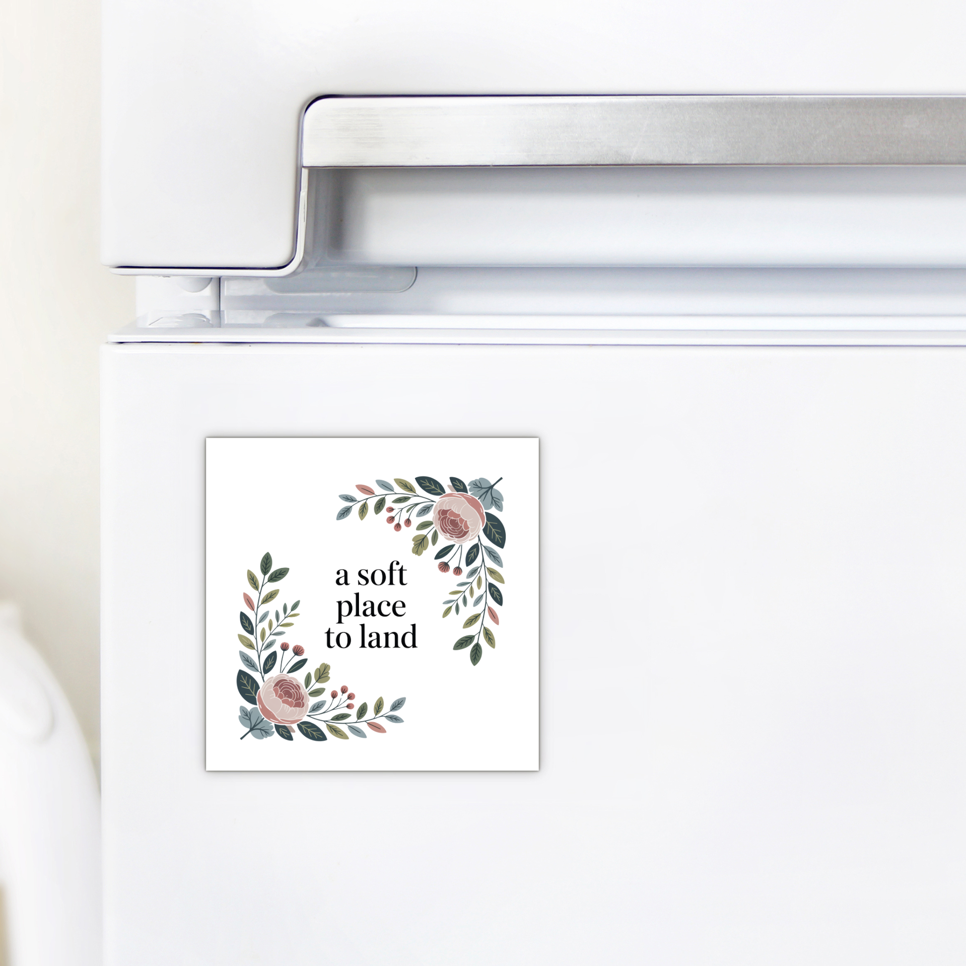 The A Soft Place to Land Floral Magnet by Mirabilia Boutique features pink and green botanical art and the text "a soft place to land," bringing cottagecore charm to your kitchen décor.