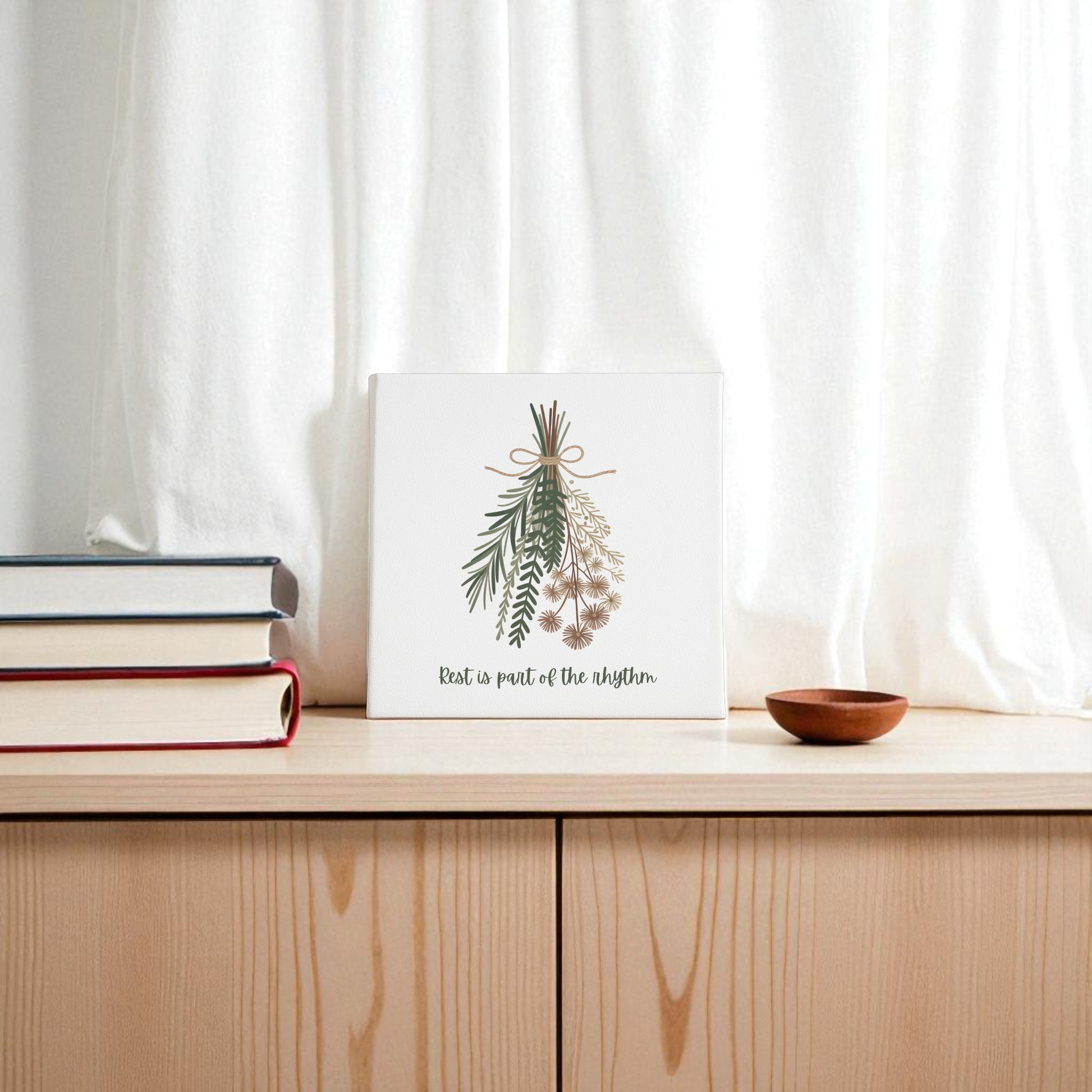 The "Rest Is Part of the Rhythm" Botanical Canvas Wall Art by Mirabilia Boutique features a minimalist herbal design and calming phrase, perfect for bringing peaceful, seasonal harmony to your space.