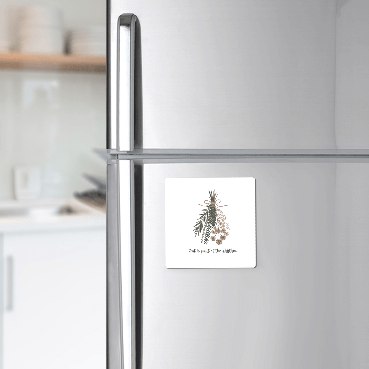 A silver fridge displays Mirabilia Boutique’s Botanical Magnet | Rest Reminder, featuring herbal sprigs and the message "Find a piece of the rhythm"—a perfect minimalist gift for slow living enthusiasts.