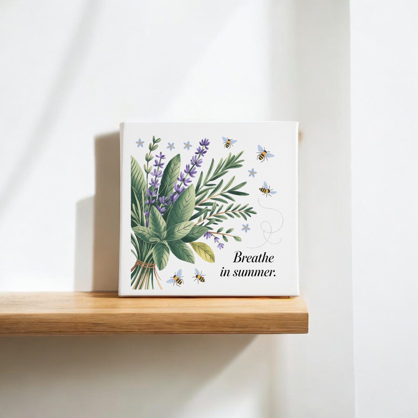 The Mirabilia Boutique "Breathe in Summer Canvas – Botanical Calm & Gentle Bees" features lavender, greenery, and bees with uplifting text, creating charming nature wall decor on a wooden shelf in bright natural light.
