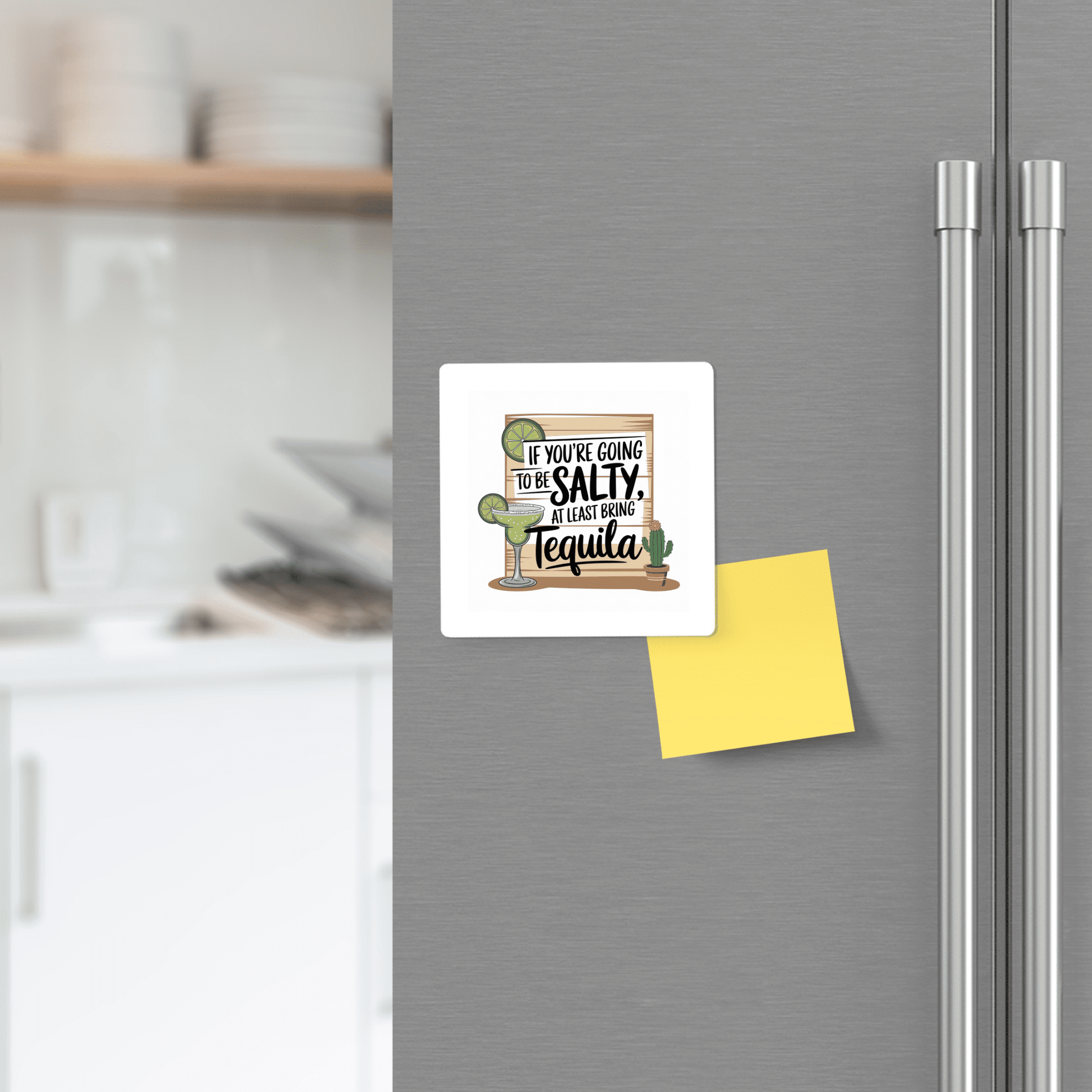 The Salty Tequila Magnet by Mirabilia Boutique, featuring a funny margarita quote and cactus design, brings playful style to your gray fridge—seen here next to a yellow sticky note in a modern kitchen.