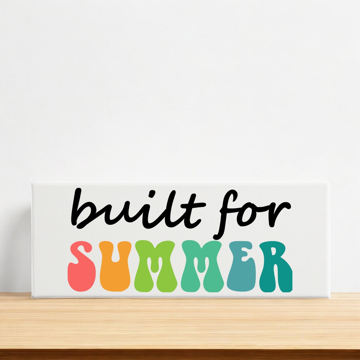 The Built for Summer Canvas – Retro Shelf Sign by Mirabilia Boutique features bold, colorful wavy letters, making it a vibrant summer decor piece perfect for brightening any mantle or shelf.