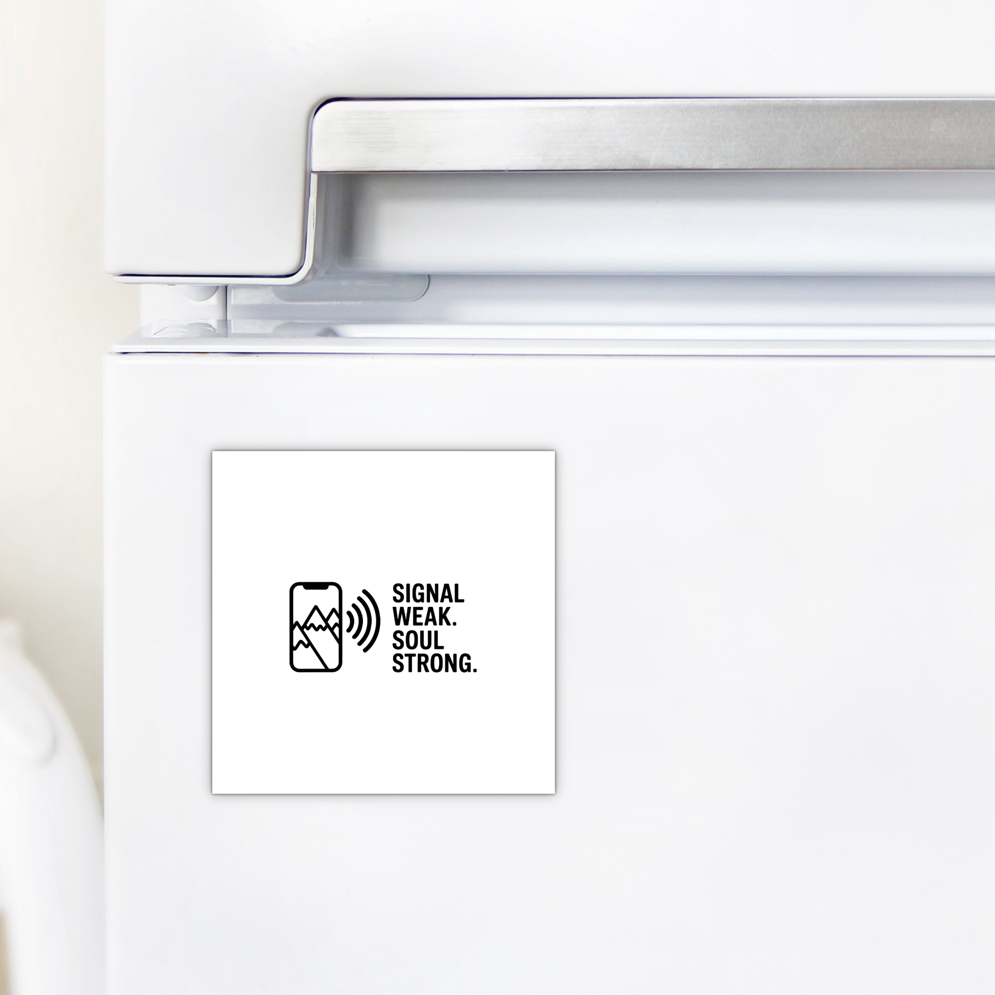 The Signal Weak Soul Strong Adventure Magnet by Mirabilia Boutique features a mountain design, a phone with a weak signal icon, and the phrase "Signal weak. Soul strong." in black on white—perfect for your white fridge.