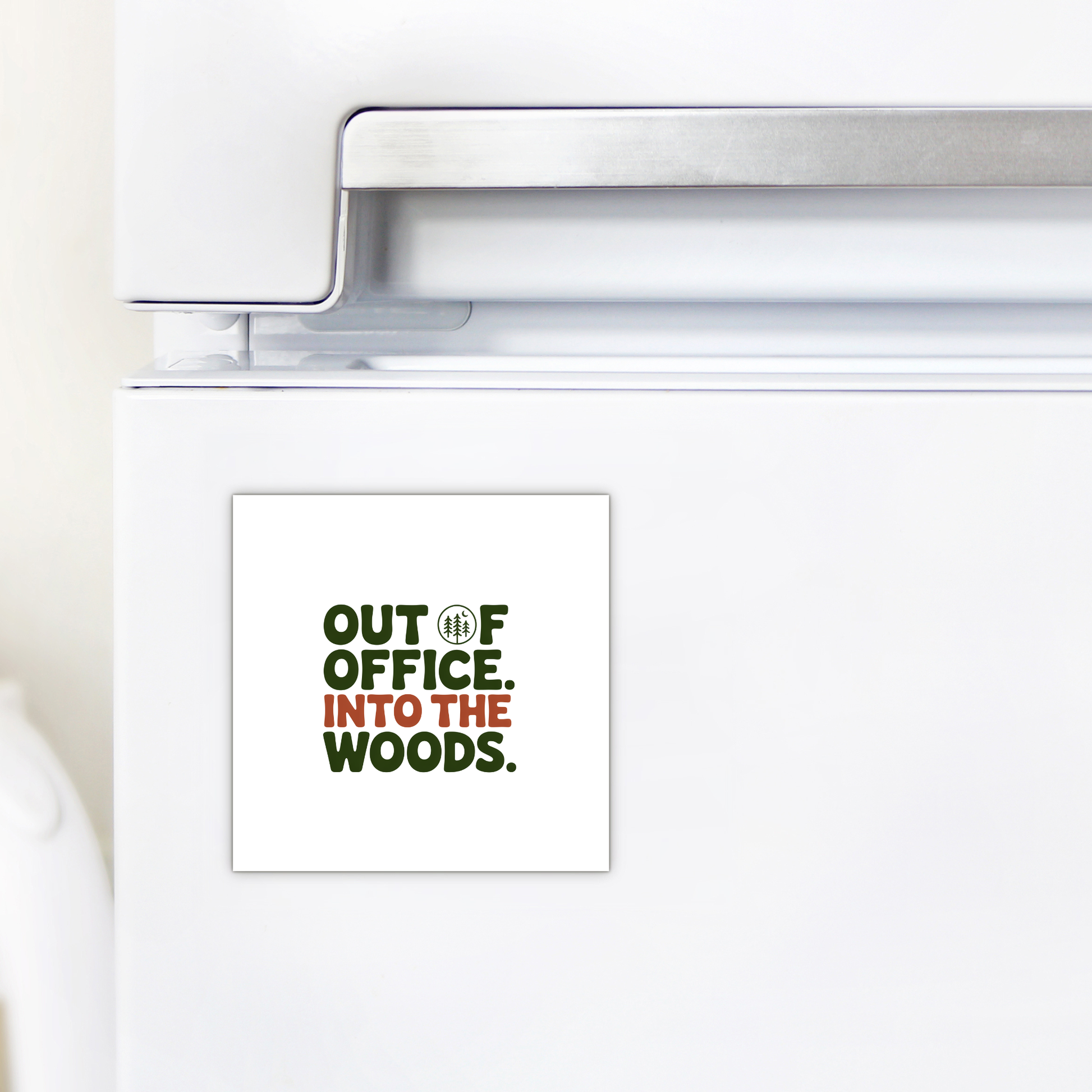 A white refrigerator displays the Mirabilia Boutique "Out of Office Into the Woods Magnet," featuring green and brown text with a tree-shaped "O"—a perfect nature-themed cabin decor for adventurers.