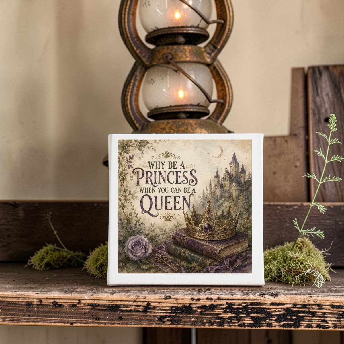 The Why Be a Princess When You Can Be a Queen Canvas by Mirabilia Boutique features an empowering quote and whimsical illustrations of a crown, books, roses, and a castle, making it the perfect fairytale wall art. Displayed on a rustic shelf with a vintage lantern in the background, this canvas adds an inspiring and decorative touch to any space.