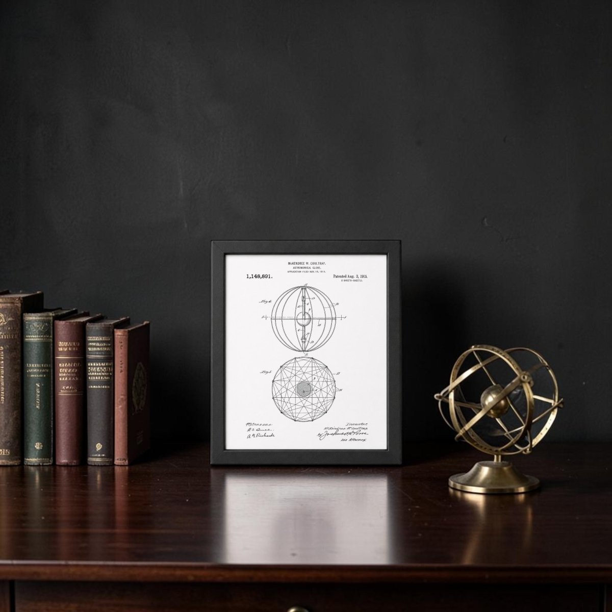 The Astronomical Globe Patent Art Print by Mirabilia Boutique is displayed on a dark wooden desk with vintage books and a brass armillary sphere, creating eye-catching celestial decor against a black wall.