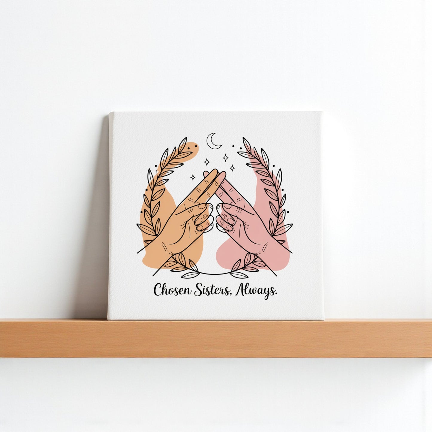 The Chosen Sisters Canvas by Mirabilia Boutique shows two hands of different skin tones touching pinkies under a crescent moon with laurels, captioned "Chosen Sisters. Always."—a heartfelt friendship gift for best friends.