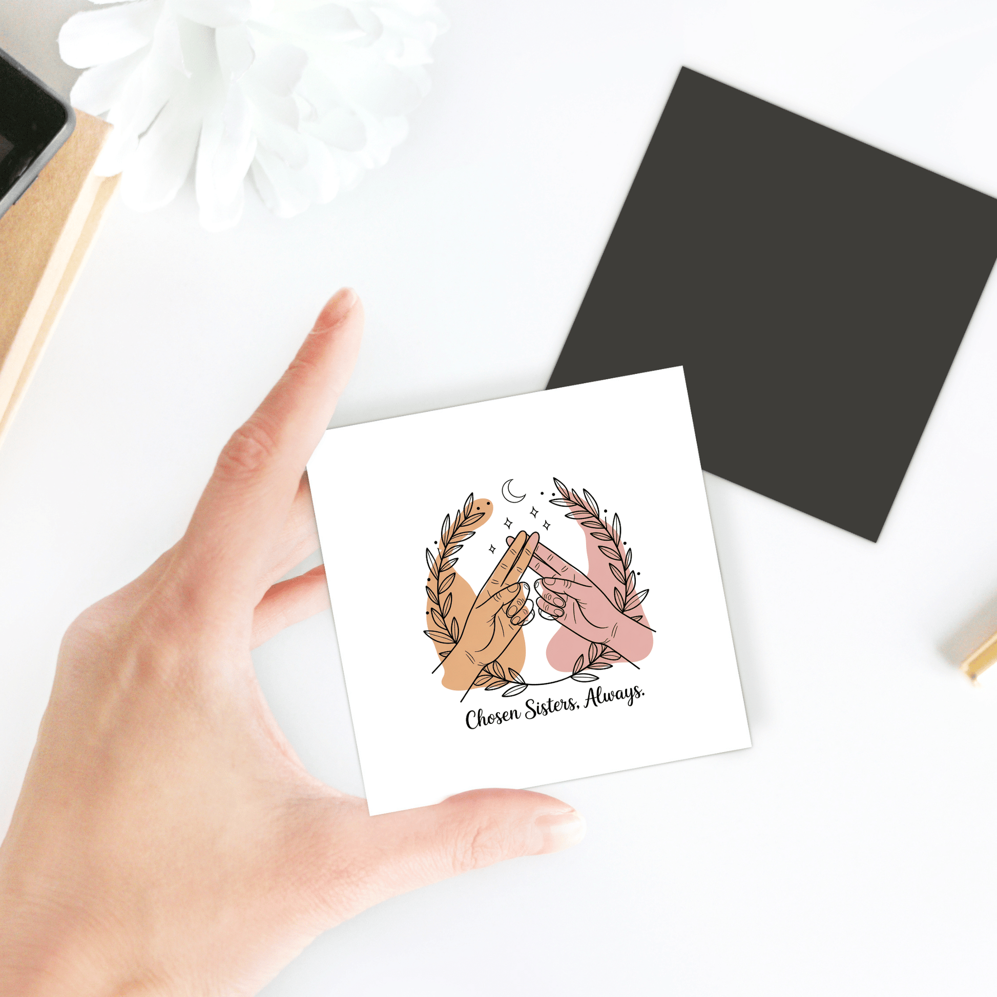 A hand holds the "Chosen Sisters Fridge Magnet" by Mirabilia Boutique, showing two hands making pinky promises amid leaves and a crescent moon. The card reads "Chosen Sisters. Always." A perfect best friend gift or friendship magnet.