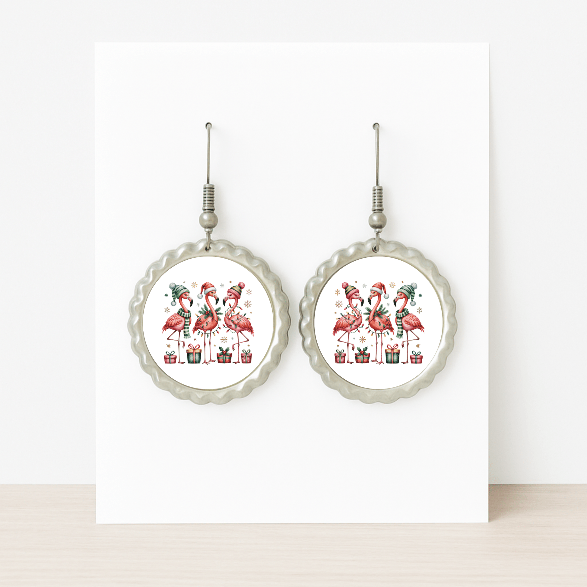 Mirabilia Boutique’s Christmas Flamingo Earrings feature four festive flamingos in holiday hats among presents. These hypoallergenic, tropical holiday jewelry pieces add playful seasonal fun—displayed on a white card.