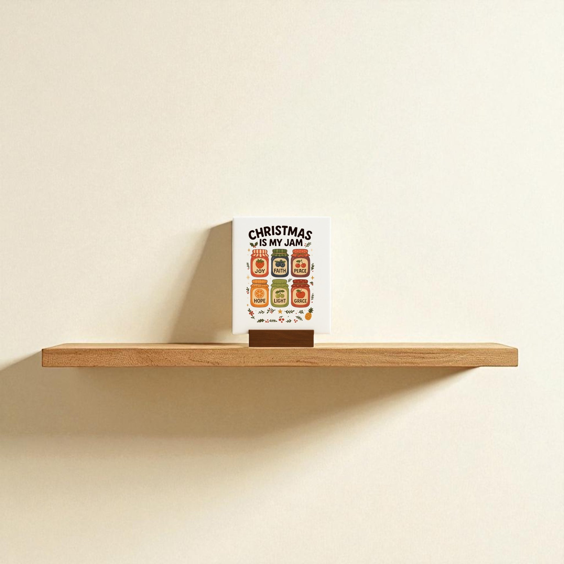 A Christmas Is My Jam Sign by Mirabilia Boutique sits on a wooden floating shelf against a beige wall, adding playful festive charm to your holiday decor.