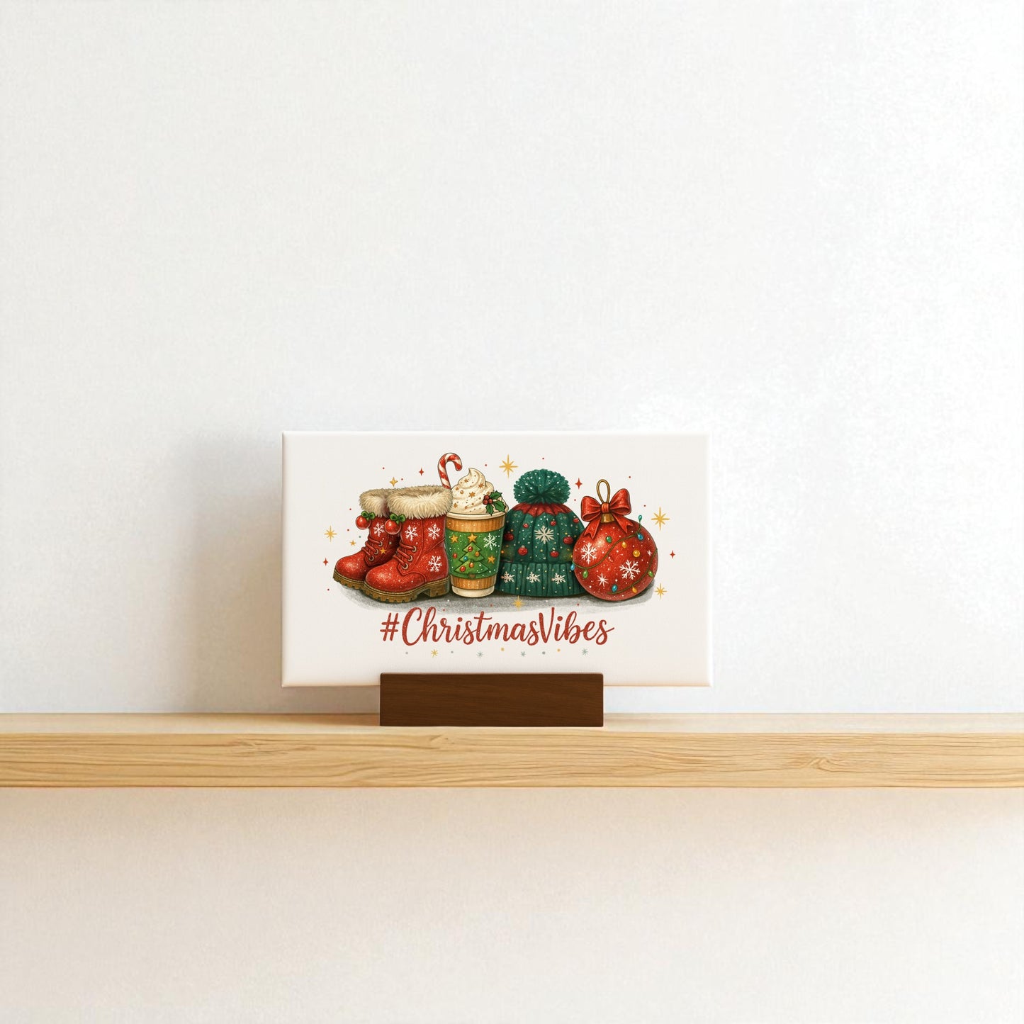 The Mirabilia Boutique Christmas Vibes 6x4 Canvas Sign sits on a wooden shelf with festive mugs and decor, featuring "#ChristmasVibes" text. A plain white wall serves as the backdrop.