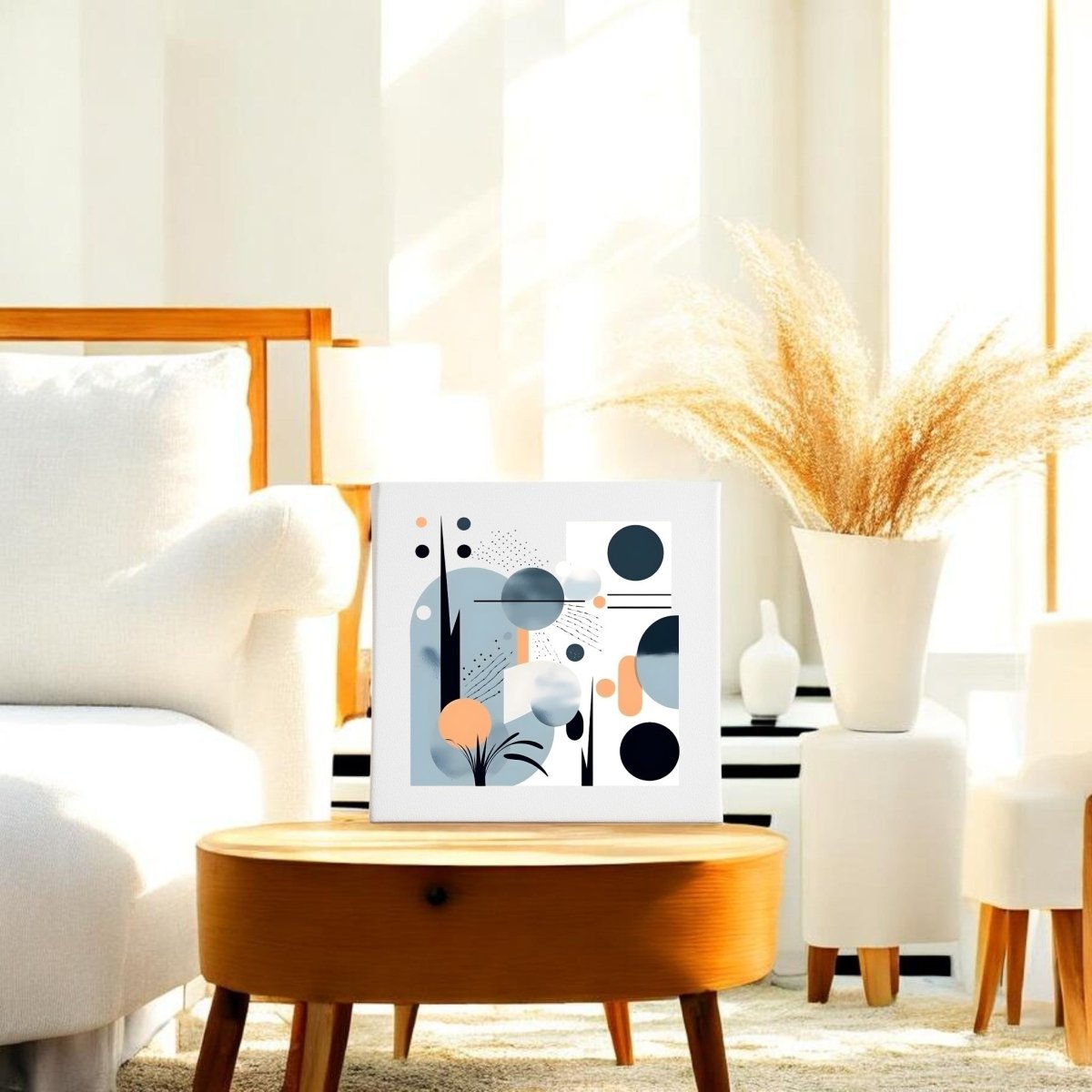 A modern living room features white furniture, a round wooden coffee table with a large vase of dried grasses, and the Mirabilia Boutique "Coastal Sunrise Mid Century Modern Canvas" artwork displaying geometric blue, orange, and gray shapes.