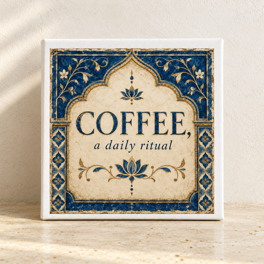 A decorative 8x8 canvas sign from Mirabilia Boutique, featuring elegant “COFFEE, a daily ritual” lettering and stylish blue floral borders from the Lapis & Lotus collection, rests on a sunlit beige surface—making it the perfect kitchen wall art for coffee décor lovers.