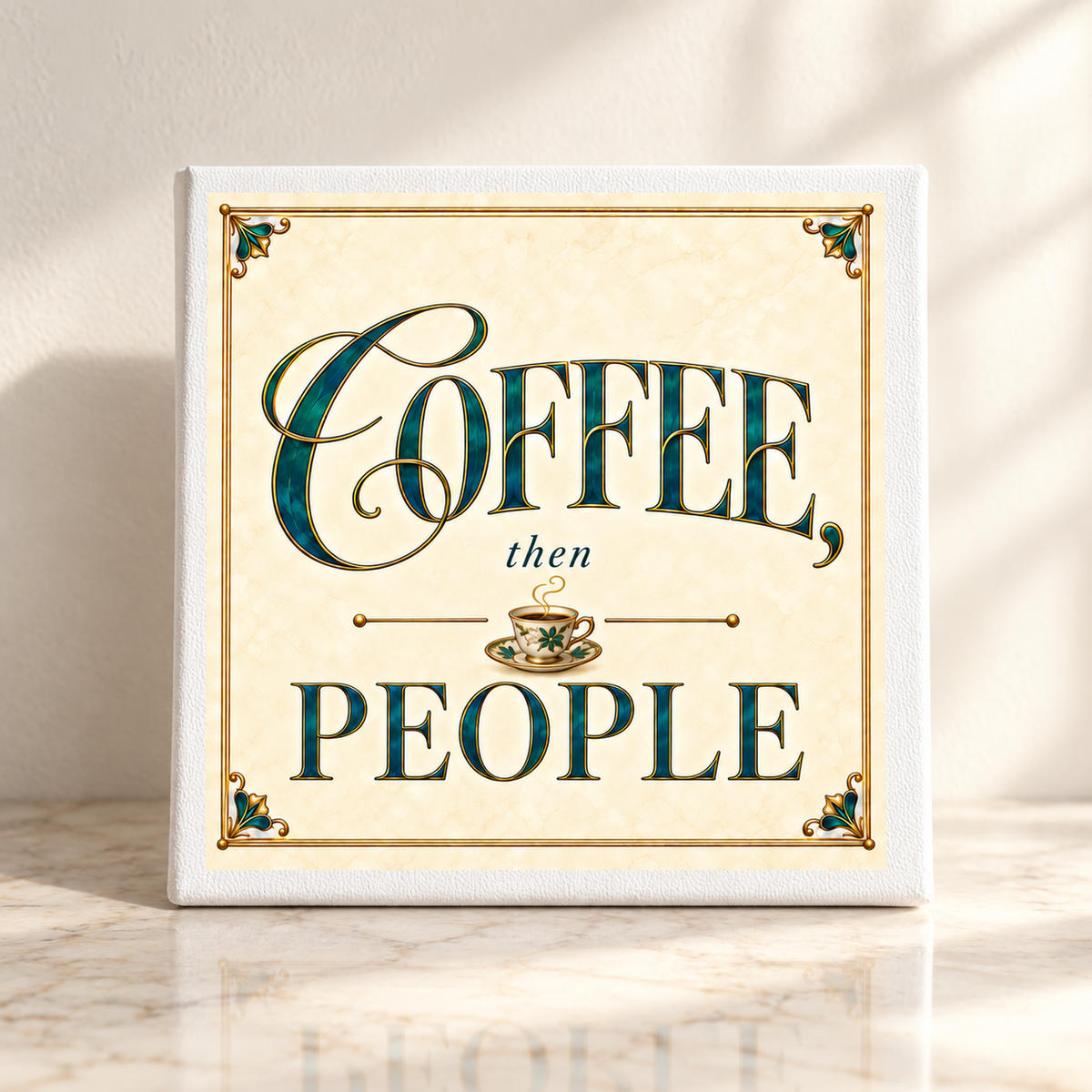 An 8x8 canvas coffee bar sign from the Gilded Reverie collection by Mirabilia Boutique rests on a marble surface, featuring the phrase “COFFEE, then PEOPLE” with a central coffee cup illustration—an inviting accent for your space. Sunlight casts gentle shadows on the wall behind this charming piece.