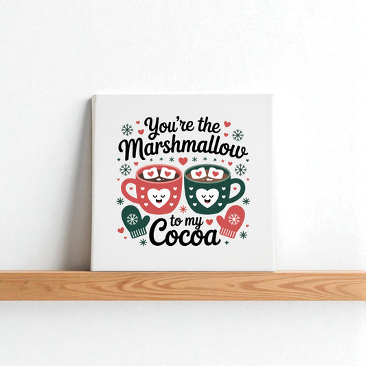 The Marshmallow to My Cocoa Sign by Mirabilia Boutique is an 8x8 winter canvas art, featuring two smiling mugs with hearts and snowflakes and the phrase “You’re the marshmallow to my cocoa”—perfect cozy kitchen decor.