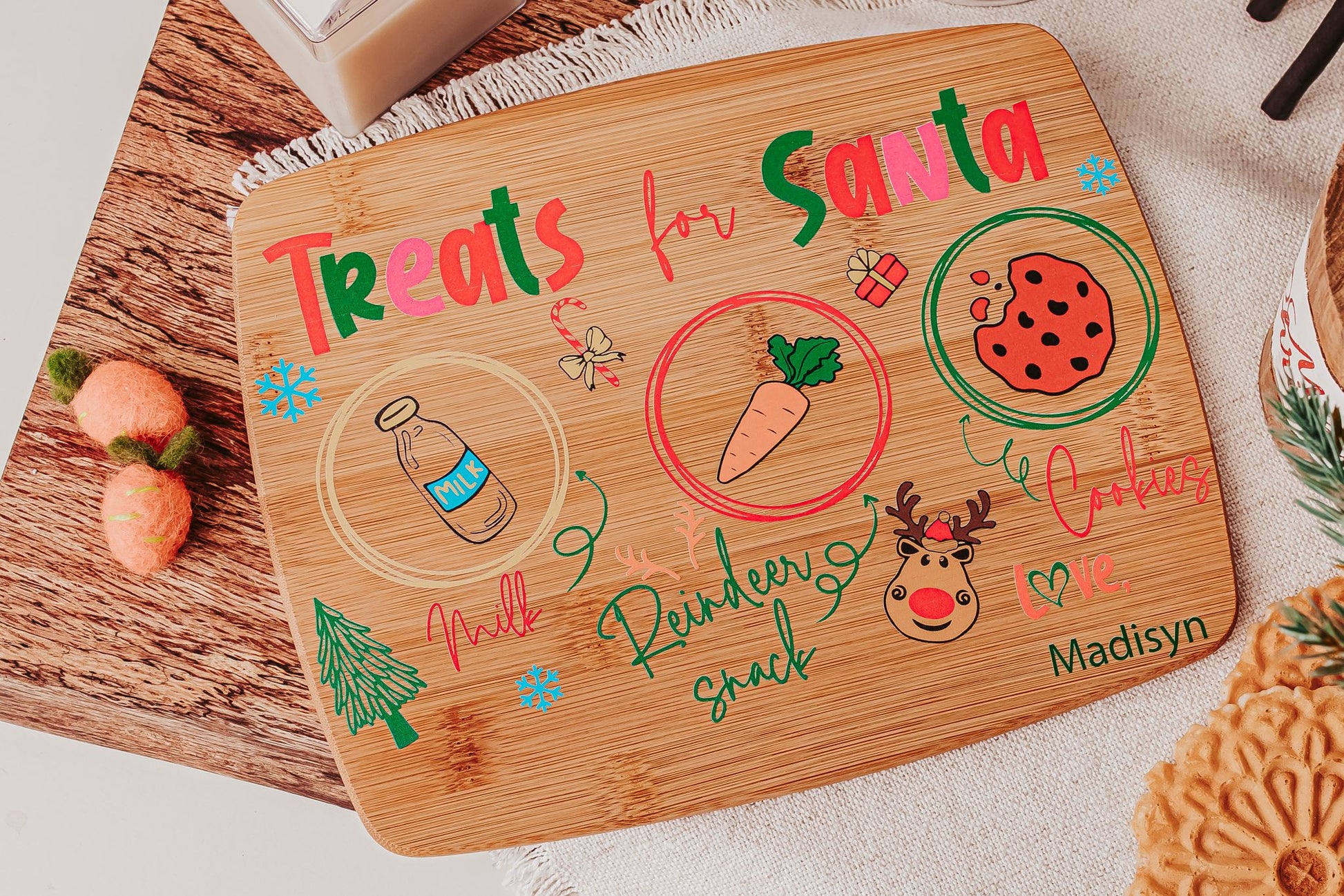 The Mirabilia Boutique Personalized Santa Treat Tray is a custom bamboo Christmas Eve board labeled for milk, cookies, and a carrot. This festive plate, ideal for Santa and his reindeer, features cute holiday designs and can include your child's name.